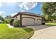 Two-car garage with light tan exterior at 6178 Spinnaker Loop, Lady Lake, FL 32159