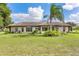 Single-story home with manicured lawn and palm tree at 6178 Spinnaker Loop, Lady Lake, FL 32159