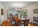 Bright dining room featuring a large wooden table, ample seating, and scenic views through the expansive windows at 9345 Silver Lake Dr, Leesburg, FL 34788