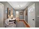 Inviting foyer featuring gray textured walls, a decorative mirror, and a charming seating area with a marble-topped table at 9345 Silver Lake Dr, Leesburg, FL 34788