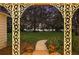 View of lush green lawn with shade trees and a lake, framed by decorative porch columns at 9345 Silver Lake Dr, Leesburg, FL 34788