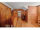 Charming hallway featuring hardwood floors and rich wood paneling, leading to cozy bedrooms at 9345 Silver Lake Dr, Leesburg, FL 34788