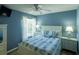 Blue bedroom with white bed and wood furniture at 1314 Lajolla Cir, The Villages, FL 32159