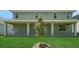 Spacious backyard featuring a covered patio, lush lawn, and newly planted tree at 14255 Crest Palm Ave, Windermere, FL 34786