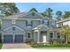 Two story home with a two car garage, stone accents, lush landscaping, and a cozy entryway at 14255 Crest Palm Ave, Windermere, FL 34786
