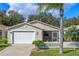 Charming single-story home featuring a two-car garage, screened-in porch, and manicured front lawn at 17478 Se 77Th Sycamore Ave, The Villages, FL 32162
