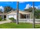 Inviting single-story home with an attached garage, screened porch, and a well-maintained lawn with a palm tree at 17478 Se 77Th Sycamore Ave, The Villages, FL 32162