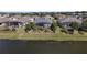 Backyard view of home with screened in lanai, lush landscaping and pond view at 2440 Pawtucket Pass, Mount Dora, FL 32757