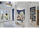 Bright foyer featuring white tile floors, blue accents, and an open view to the living area with custom bookshelves at 2440 Pawtucket Pass, Mount Dora, FL 32757