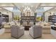 Library with large windows, chandelier, comfortable seating and bookshelves at 2440 Pawtucket Pass, Mount Dora, FL 32757