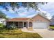 Charming one-story house featuring a two-car garage and lush green landscaping at 2502 Loch Ness Ct, Leesburg, FL 34788