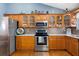 Well-equipped kitchen with wooden cabinets, stainless steel appliances, and granite countertops at 2502 Loch Ness Ct, Leesburg, FL 34788