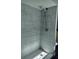 Updated shower with marble-style tile and handheld shower head at 33710 Linda Ln, Leesburg, FL 34788