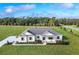 Aerial view of a single-story home with a well-manicured lawn, landscaping, and long driveway at 38805 Ranch Gate Blvd, Umatilla, FL 32784