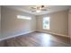 Bright bedroom with wood-look floors, ceiling fan and natural light from two windows at 504 4Th Ave, Wildwood, FL 34785