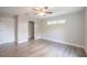 Neutral bedroom with wood-look floors, white door, and light from a window at 504 4Th Ave, Wildwood, FL 34785