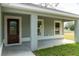 Inviting front porch featuring a decorative front door and ample natural light from nearby windows at 504 4Th Ave, Wildwood, FL 34785