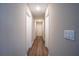 Well-lit hallway with multiple white doors and hardwood flooring at 504 4Th Ave, Wildwood, FL 34785