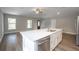 Modern kitchen island with stainless dishwasher, hardwood floors, and a sink overlooking the living area at 504 4Th Ave, Wildwood, FL 34785