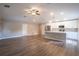 Spacious open-concept living space with modern gray walls, hardwood flooring, and an adjacent white kitchen at 504 4Th Ave, Wildwood, FL 34785