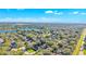 High-angle view of a community near a lake, with mature trees and a road bordering the area at 929 Magnolia Blossom Ct, Apopka, FL 32712