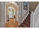 Welcoming hallway featuring tile floors, an arched entryway, and a staircase with white railings at 929 Magnolia Blossom Ct, Apopka, FL 32712