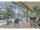 Charming screened-in patio features a comfortable seating arrangement and a relaxing view of the pool at 929 Magnolia Blossom Ct, Apopka, FL 32712