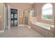 Bathroom features a soaking tub, shower, and beige tile floors at 1148 Calloway Cir, Clermont, FL 34711