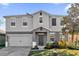 Two-story home with gray siding, two-car garage and well landscaped front yard at 1961 Nations Way, Saint Cloud, FL 34769