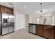 Open kitchen with stainless steel refrigerator, granite countertops, and tile flooring at 1961 Nations Way, Saint Cloud, FL 34769