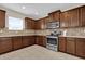 Kitchen with stainless steel appliances, wood cabinetry, and tile backsplash at 1961 Nations Way, Saint Cloud, FL 34769