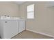 Bright laundry room featuring a white washer, dryer, and tiled flooring at 1961 Nations Way, Saint Cloud, FL 34769