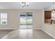 Living and dining area with tiled floors, sliding door to screened in patio and kitchen access at 1961 Nations Way, Saint Cloud, FL 34769