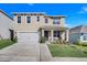 Two-story house with beige exterior, two-car garage, and a nicely landscaped yard at 2011 Chickasaw Blvd, Davenport, FL 33837