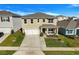 Two-story house with a beige exterior, white garage door, and landscaped front yard at 2011 Chickasaw Blvd, Davenport, FL 33837