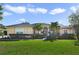 Single-story home with tan exterior, lush landscaping, and palm trees at 23436 Valderama Ln, Sorrento, FL 32776