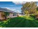 Large backyard displaying manicured lawn and lush landscape as seen from back of home at 33516 Overton Dr, Leesburg, FL 34788
