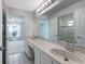 Bright bathroom boasts double sinks with granite counters, tile floors, and glass shower at 33516 Overton Dr, Leesburg, FL 34788
