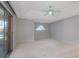 Spacious main bedroom with neutral carpet, sliding glass doors and fan at 33516 Overton Dr, Leesburg, FL 34788