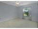 Neutral bedroom with a window, neutral carpet, fan, and white trim at 33516 Overton Dr, Leesburg, FL 34788