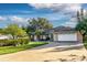 Well-kept home boasting a spacious driveway, an attached two-car garage, and manicured green lawn at 33516 Overton Dr, Leesburg, FL 34788