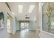 Bright living room with vaulted ceilings, skylights, and wood-look floors as seen from the entry at 33516 Overton Dr, Leesburg, FL 34788