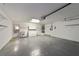 Spacious garage with utility sink, white cabinets, and overhead storage racks at 2552 English Ivy Cir, The Villages, FL 32162