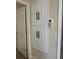 Hallway storage with white cabinets and black hardware at 2552 English Ivy Cir, The Villages, FL 32162