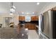 Modern kitchen with stainless steel appliances, dark backsplash, and granite countertops at 2552 English Ivy Cir, The Villages, FL 32162