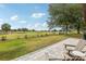 Scenic backyard with a paver patio, a serene pond, lush green grass, and golf course views at 36729 Alaqua Ct, Eustis, FL 32736