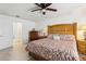 Spacious bedroom featuring a wood-frame bed, ceiling fan, and neutral decor at 36729 Alaqua Ct, Eustis, FL 32736