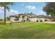 Well-maintained single-story home with a manicured lawn and a three-car garage at 36729 Alaqua Ct, Eustis, FL 32736
