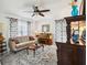 Cozy living room with a sofa, piano, patterned curtains and a ceiling fan at 36729 Alaqua Ct, Eustis, FL 32736