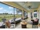 Large screened in lanai overlooking the golf course with multiple seating areas and ceiling fans at 36729 Alaqua Ct, Eustis, FL 32736